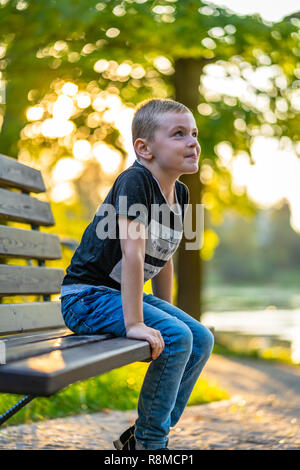 Son Showing His Tongue to His Motther  in Park in Autum, Colorful Background, Sunny Day - Caption on Shirt 'I am, It`s now or never, Iask myself, Why 